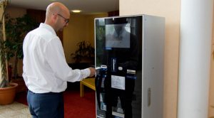 Man using Pay station payment terminal in hotel